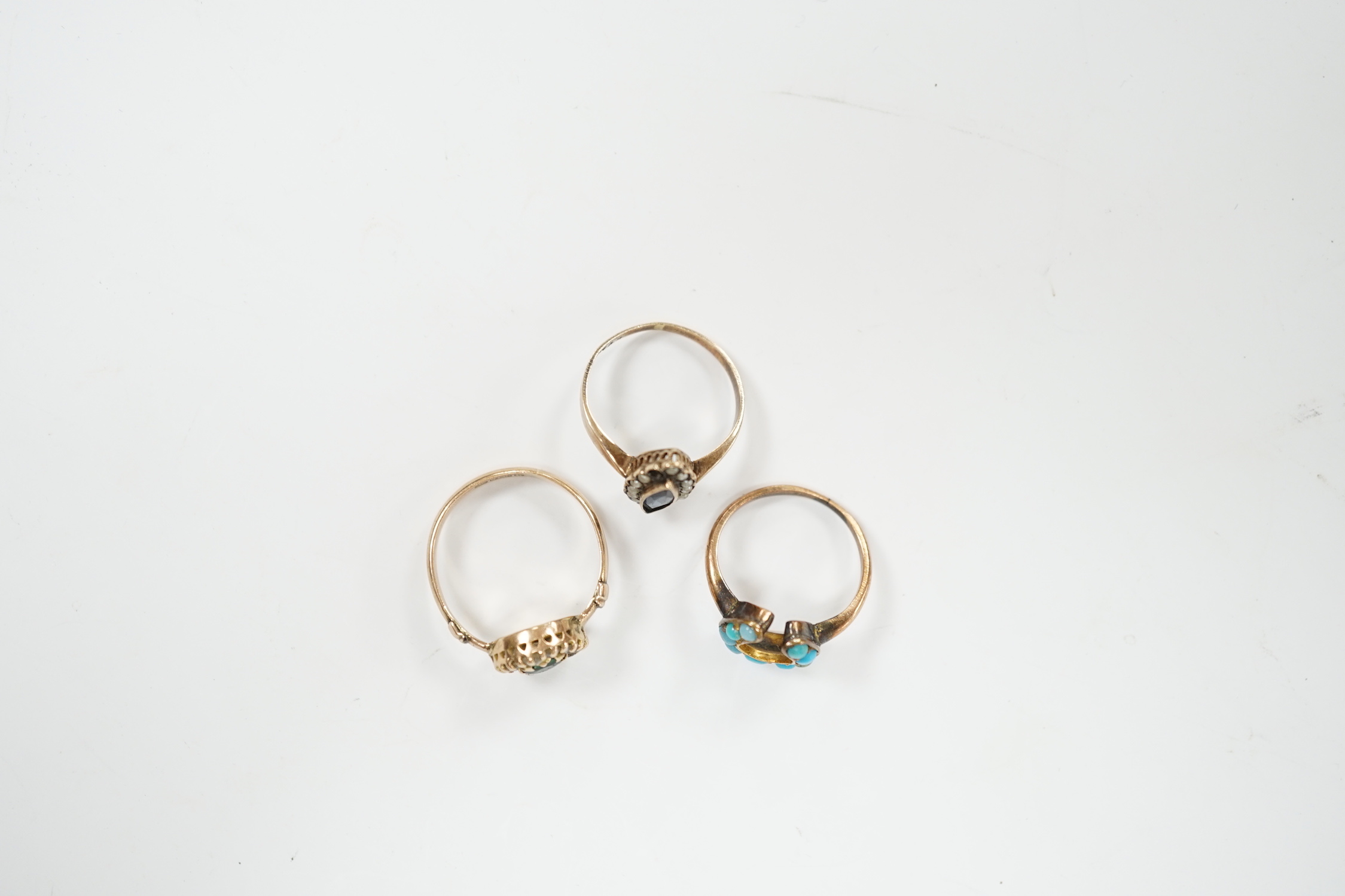 An early 20th century 9ct gold and two colour pastes set circular cluster ring, a 333 (8ct) ring and one other yellow metal and turquoise set horseshoe ring, gross weight 5.6 grams.